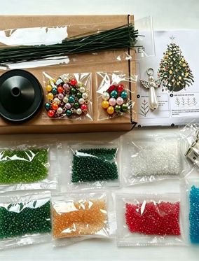 Materiais do kit sobre uma mesa, com pérolas separadas, base, hastes e instruções.