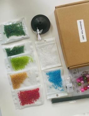 Materiais da árvore de Natal organizados ao lado da caixa do kit.